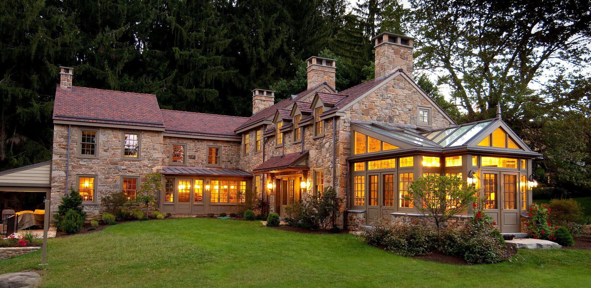 A large stone house with a lawn in front of it.