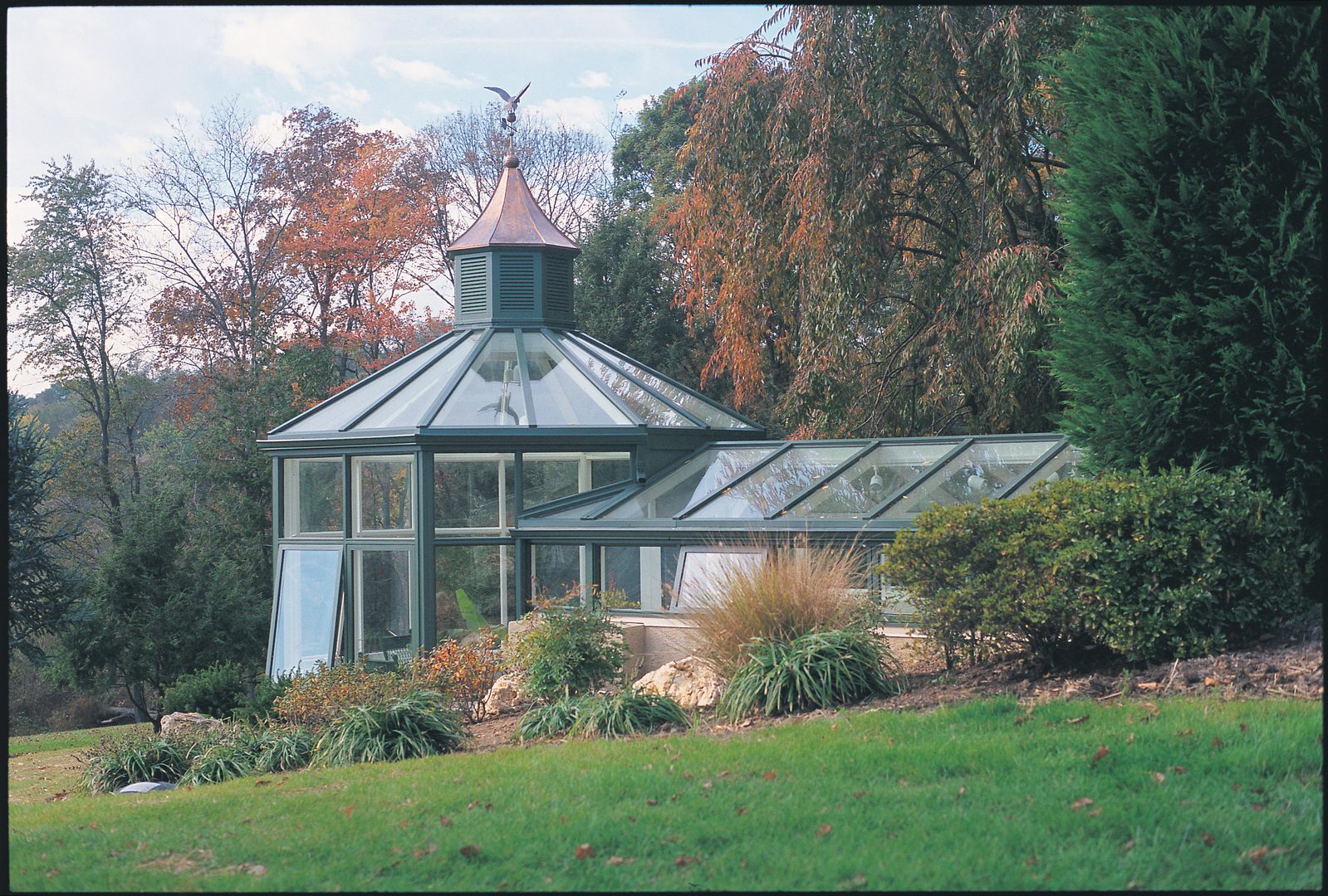 A large greenhouse with a metal roof and glass windows.