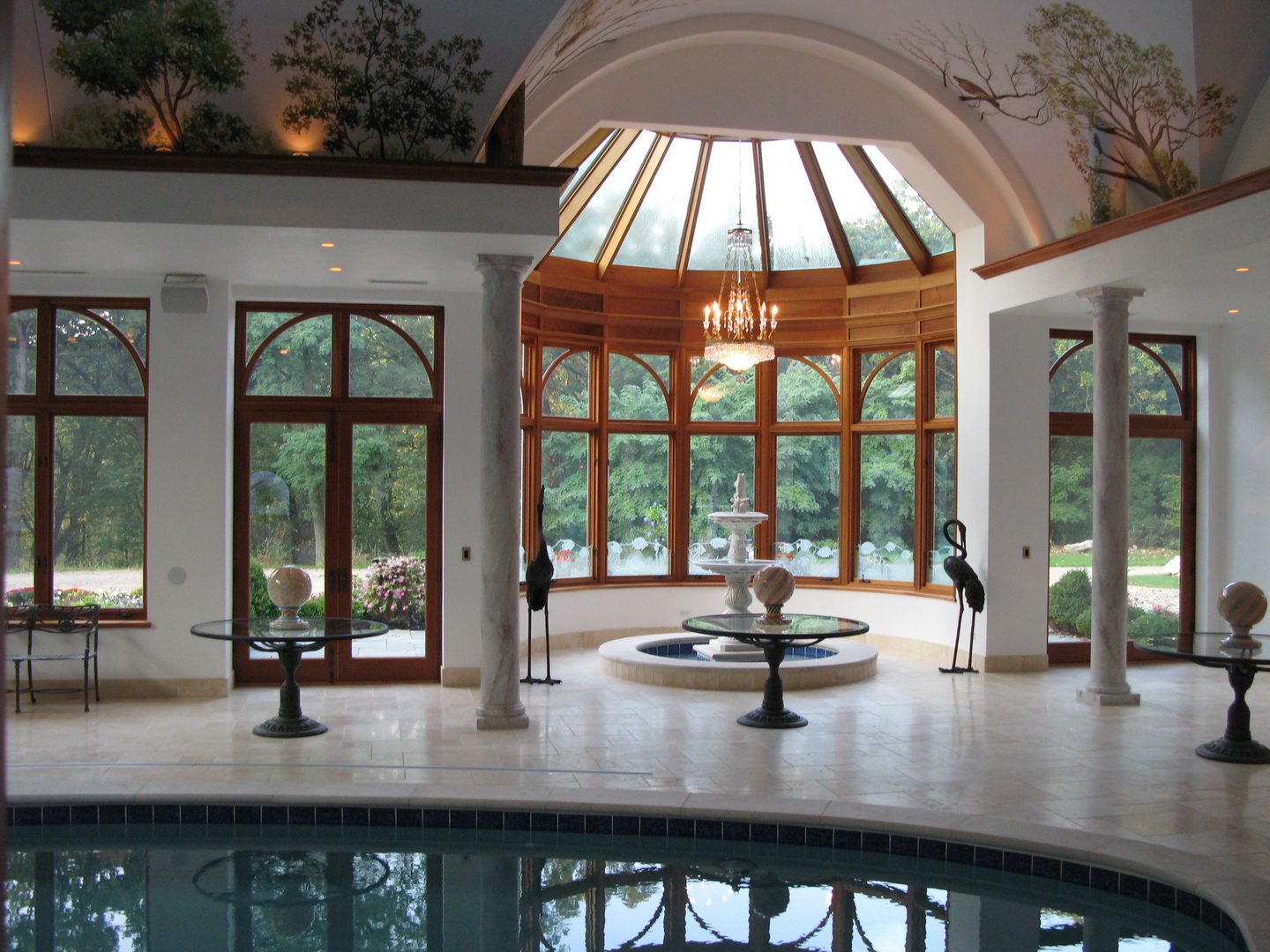 A large indoor pool with a fountain and chandelier.