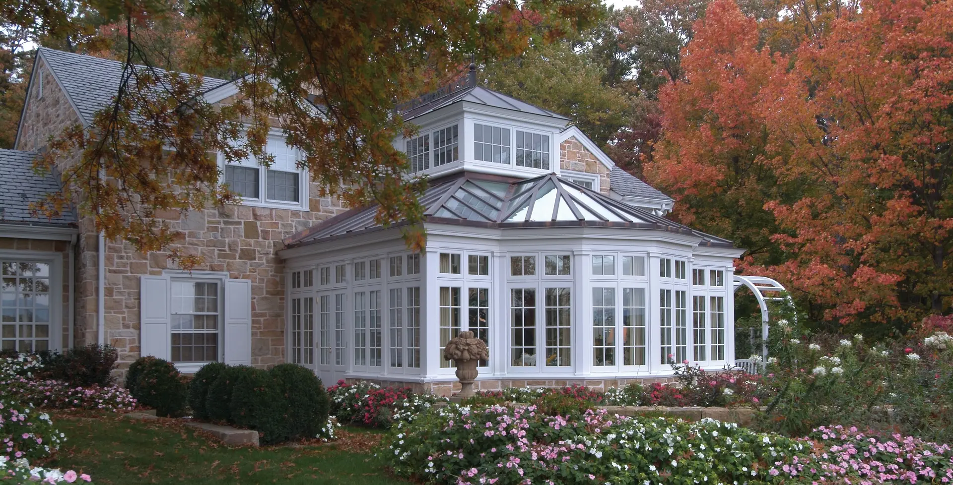 A large white house with flowers in front of it.