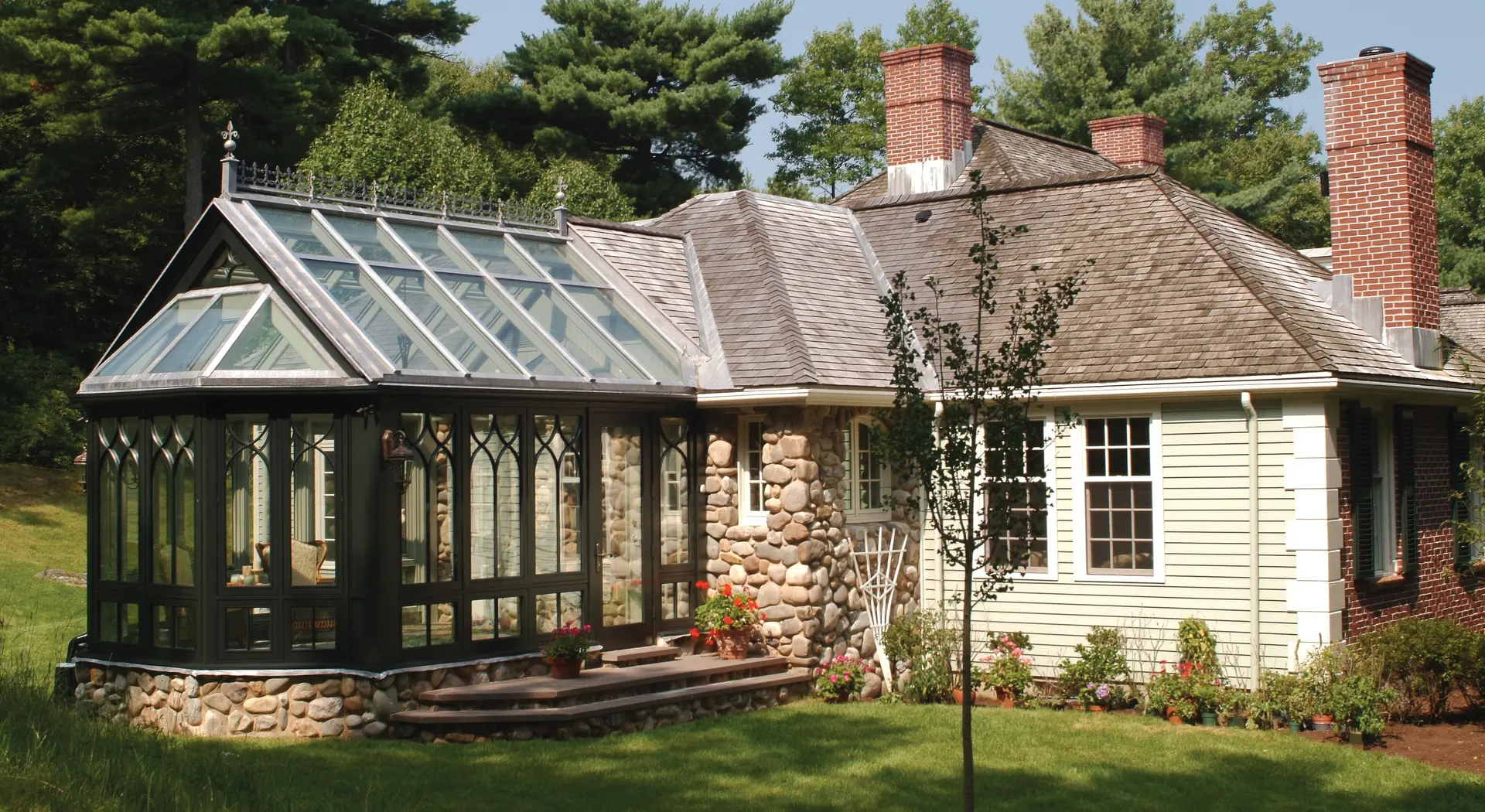 A house with a large glass roof and stone walls.