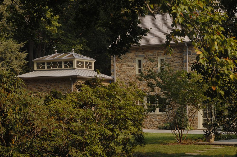 A large stone house with trees in the background.