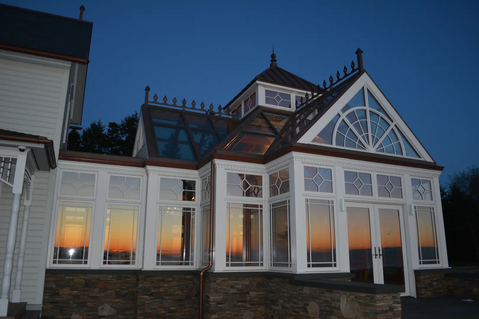 A large white building with glass windows at sunset.