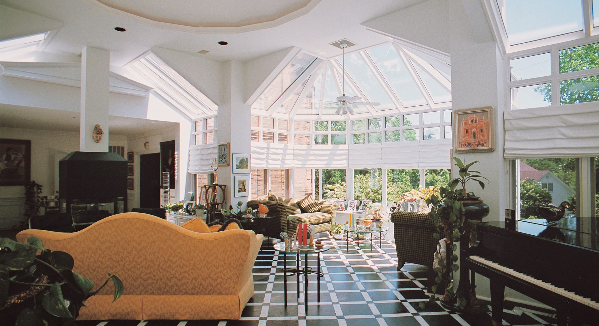 A living room with a large glass ceiling and a lot of windows.