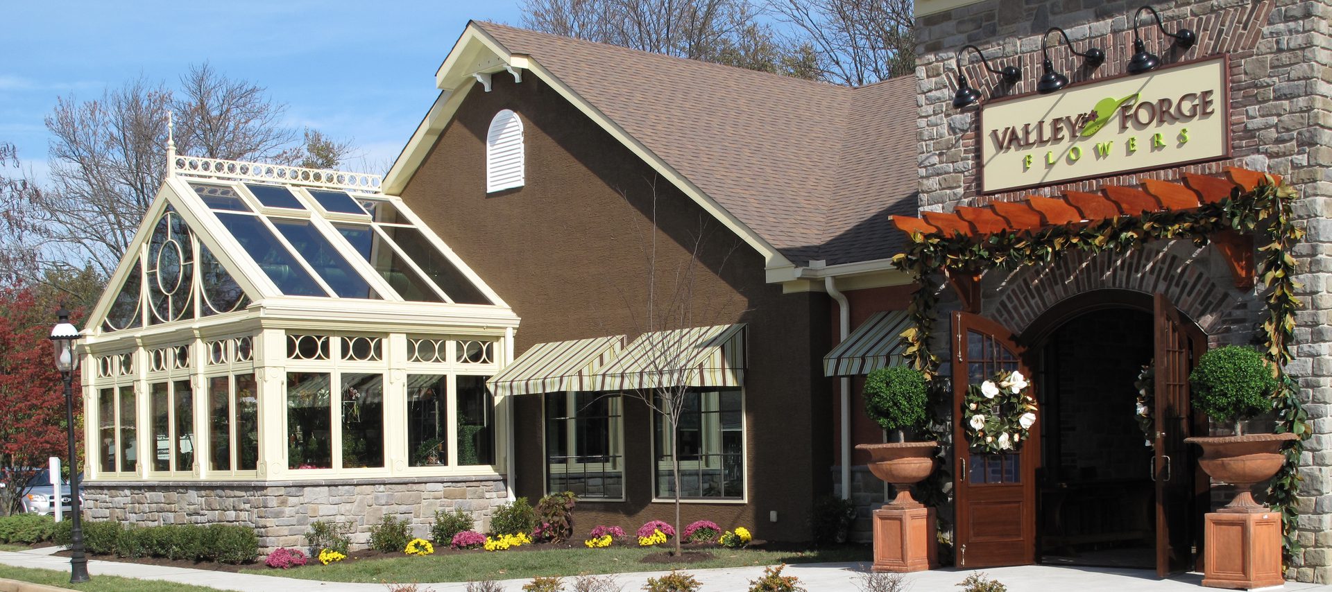 A brown house with flowers in front of it.