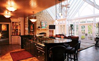 e3c69fc3ba7f403534745199dd2b7b39 A kitchen with a bar and chairs in it