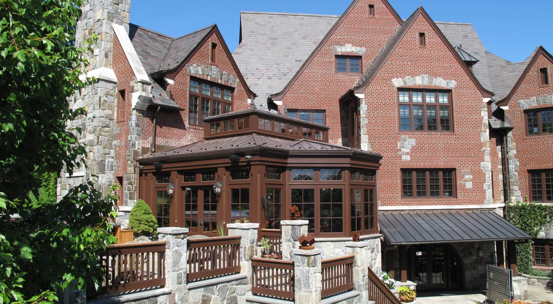 A large brick house with a balcony and patio.