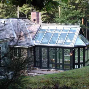 A large glass house with a metal roof.