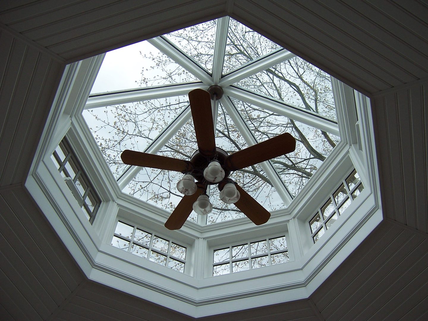 A ceiling fan in the center of a room.