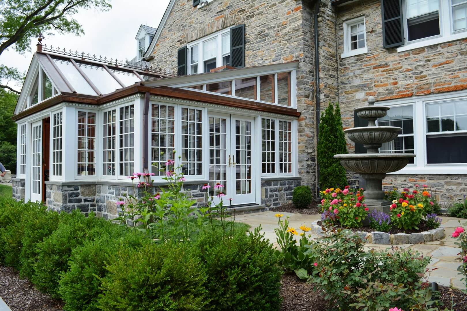 A large brick house with a fountain in the back yard.