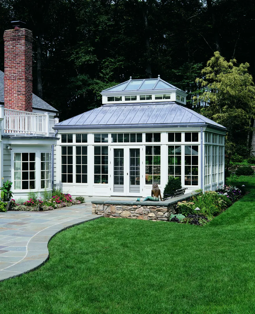 A large white house with a patio and garden.
