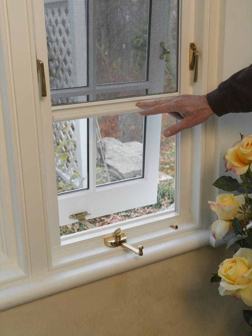 A person touching the window of a house