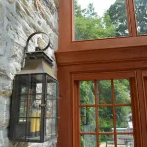 A lantern hanging on the side of a stone wall.