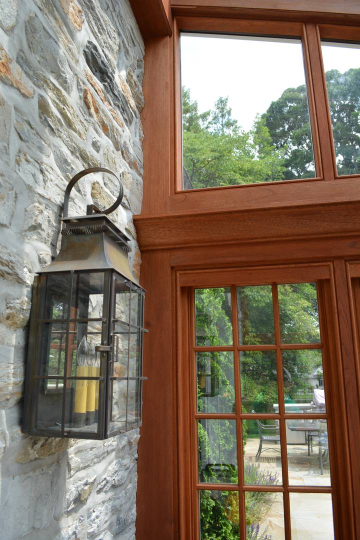 A lantern hanging on the side of a stone wall.