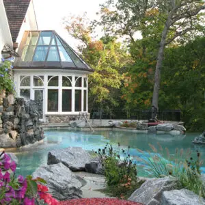 A pool with rocks and flowers in the foreground.