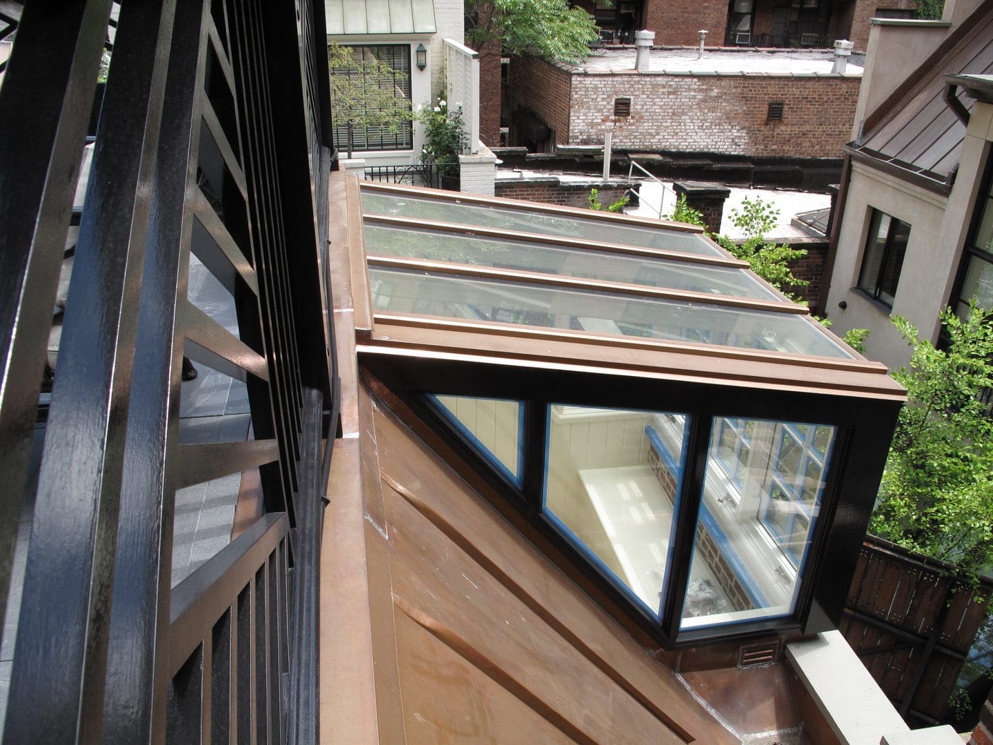A wooden deck with a glass roof and a window.