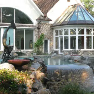 A large house with a pond and water features.