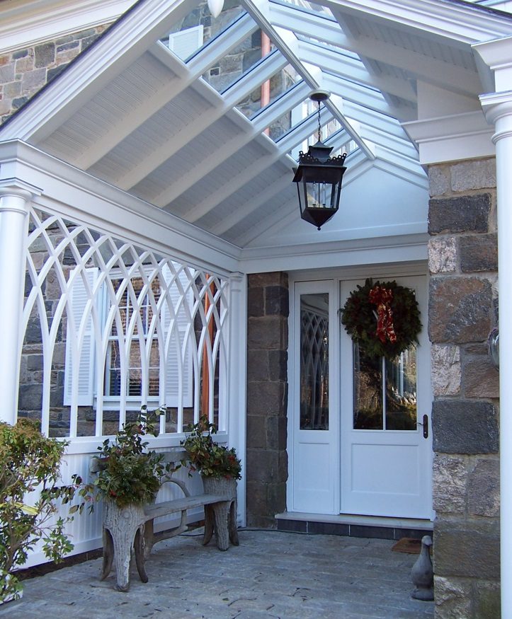 A porch with a white door and a wreath on the front.