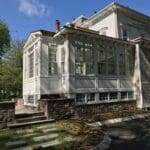 A white house with a stone walkway and steps leading to it.