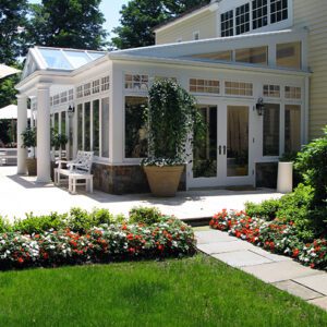 A large patio with flowers and benches in the yard.