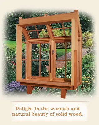 A wooden window frame with a view of the garden.