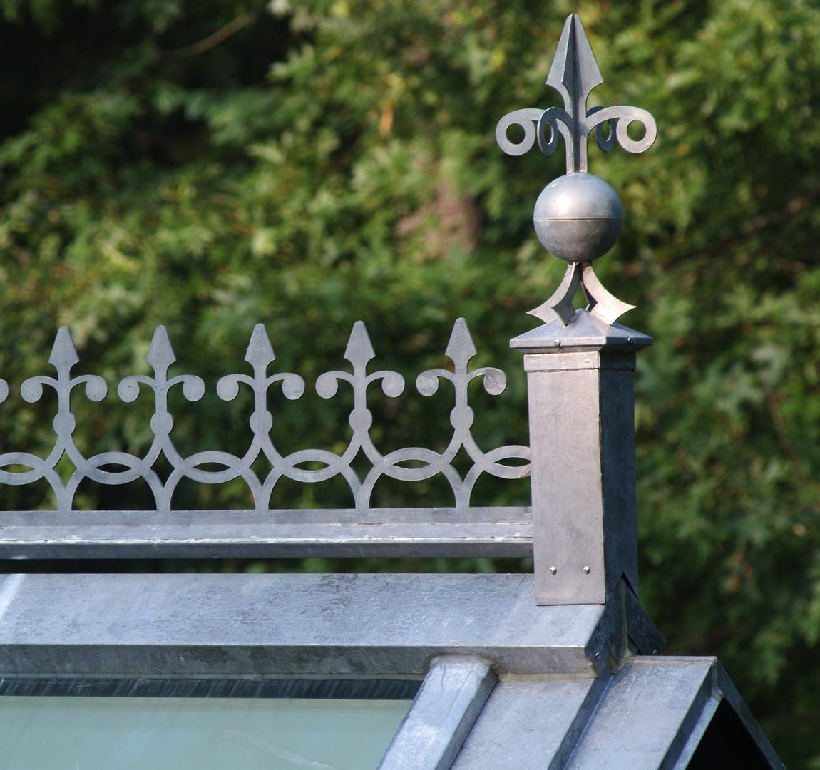 A close up of the top of a building with metal fence.