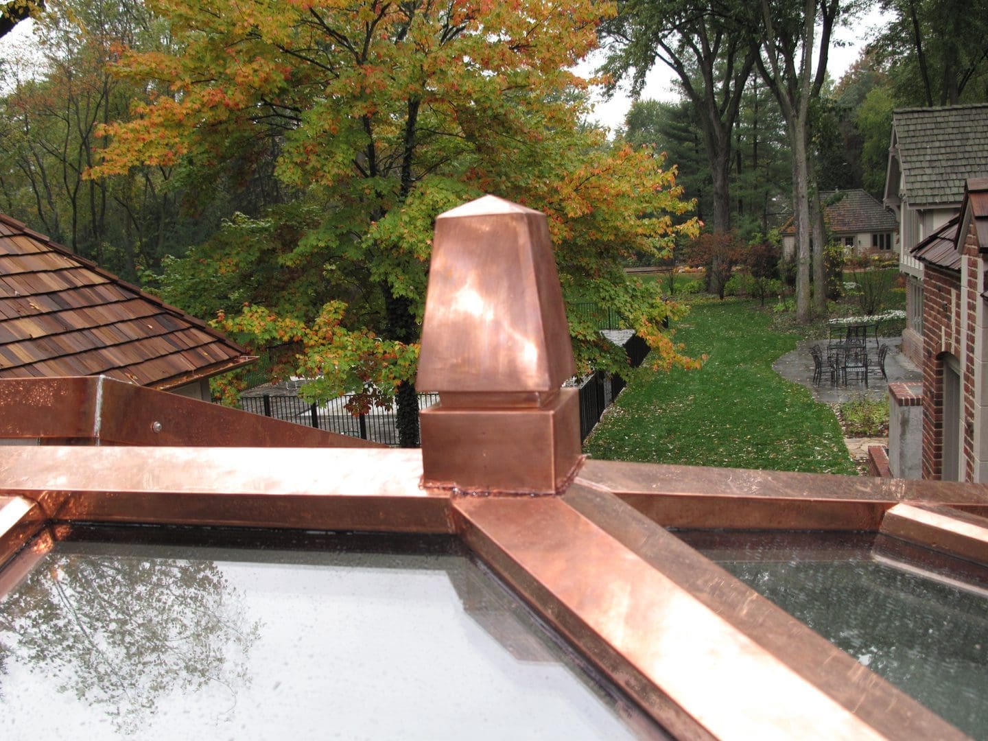 A copper roof with trees in the background
