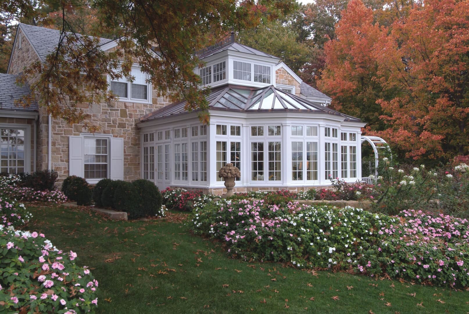 A large white house with flowers in the yard.