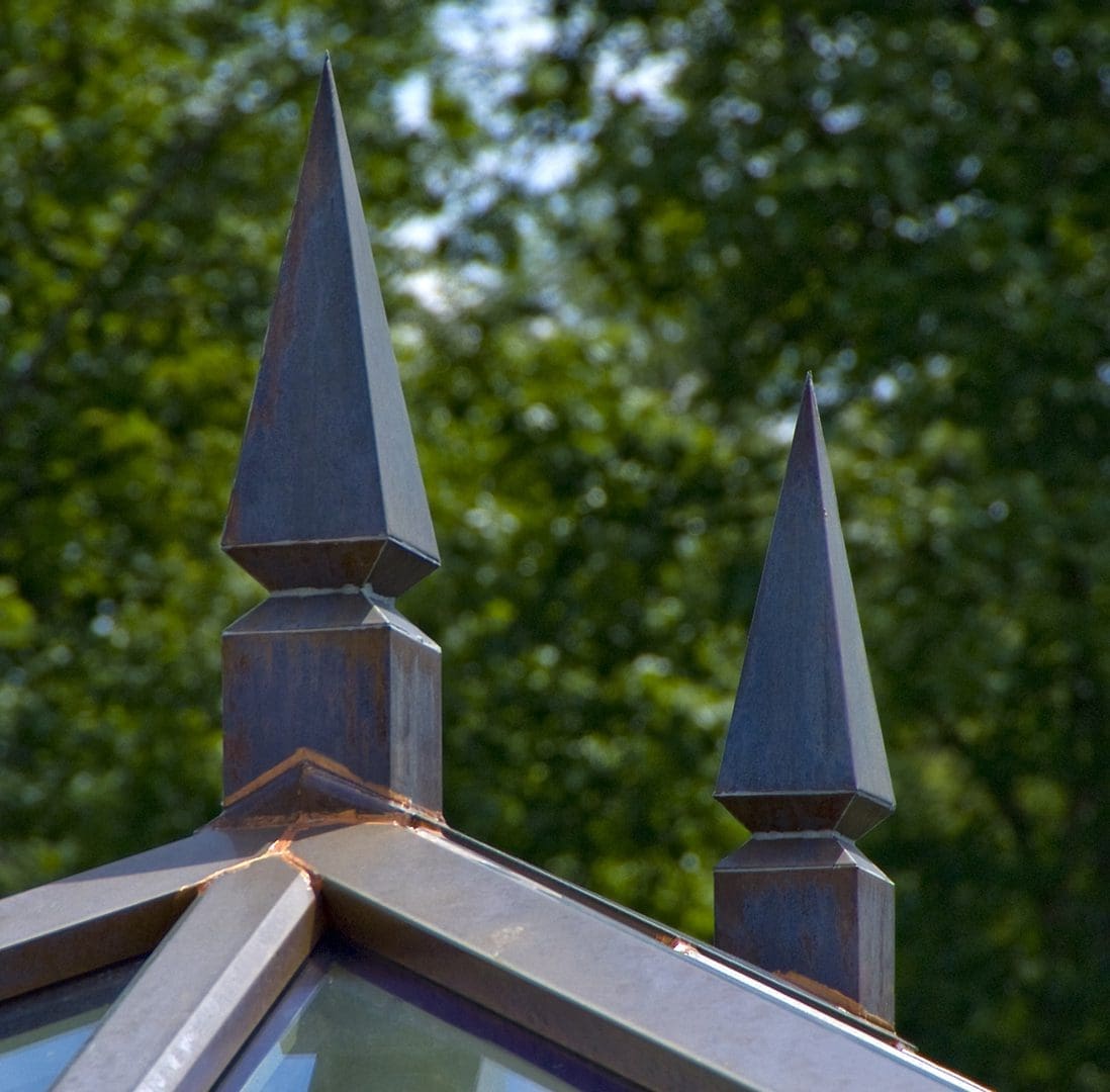 A close up of the top of a building with trees in the background
