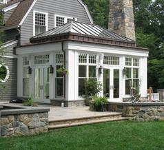 A large white house with a stone wall and patio.