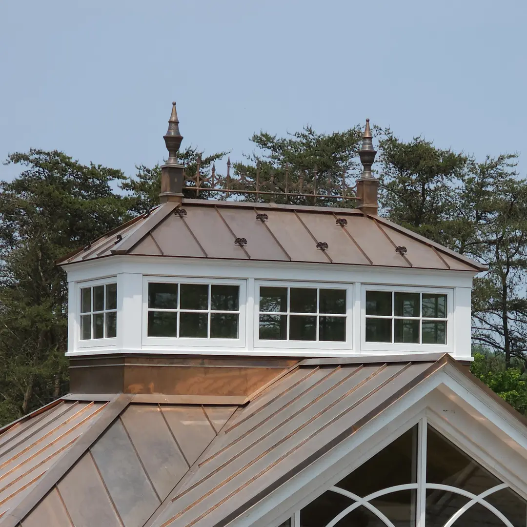 A roof with windows and a cupola on top of it.