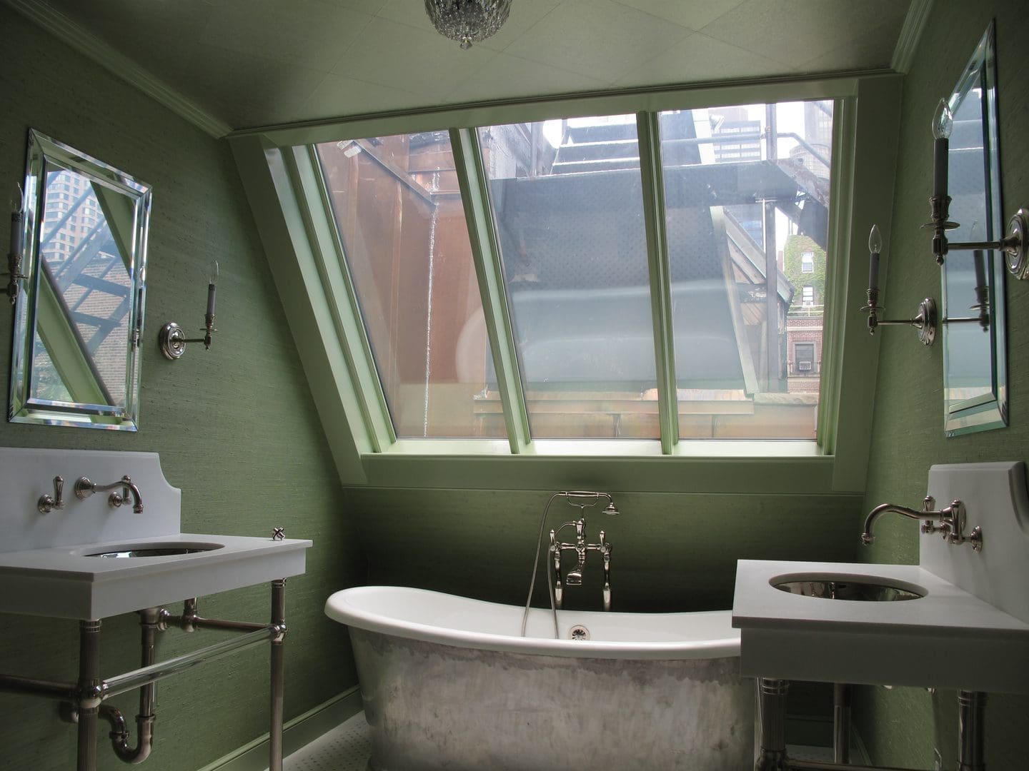 A bathroom with a tub, sink and mirror.