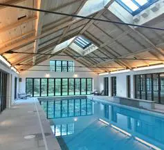 A large indoor swimming pool with a skylight.