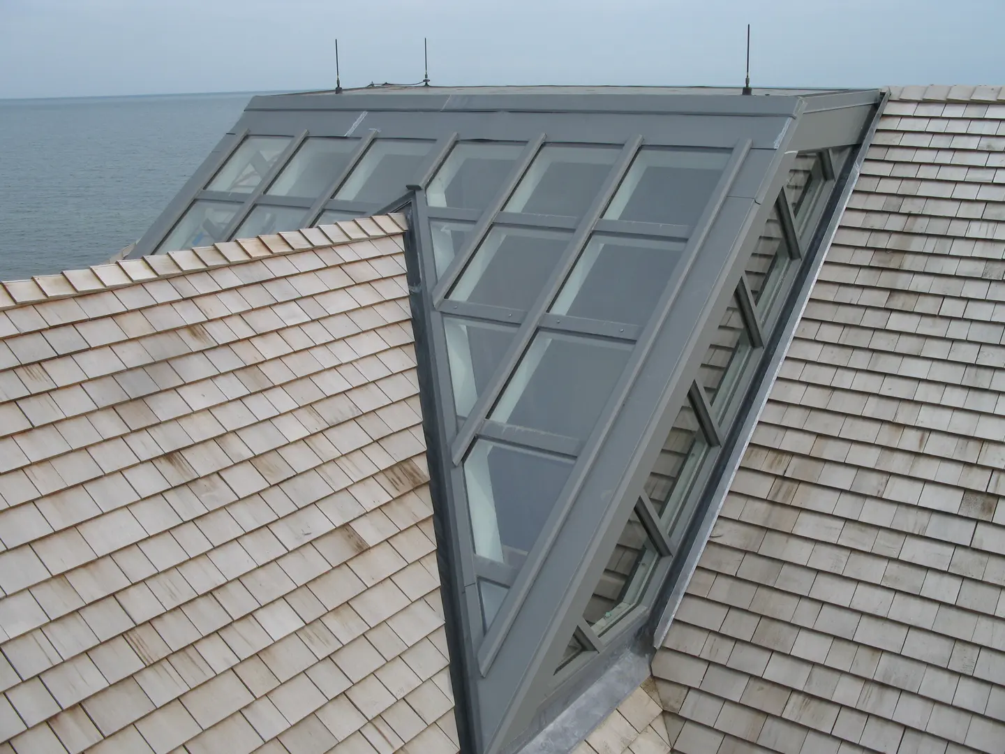 A roof with two skylights and one is open.