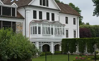 A large white house with a garden in front of it.